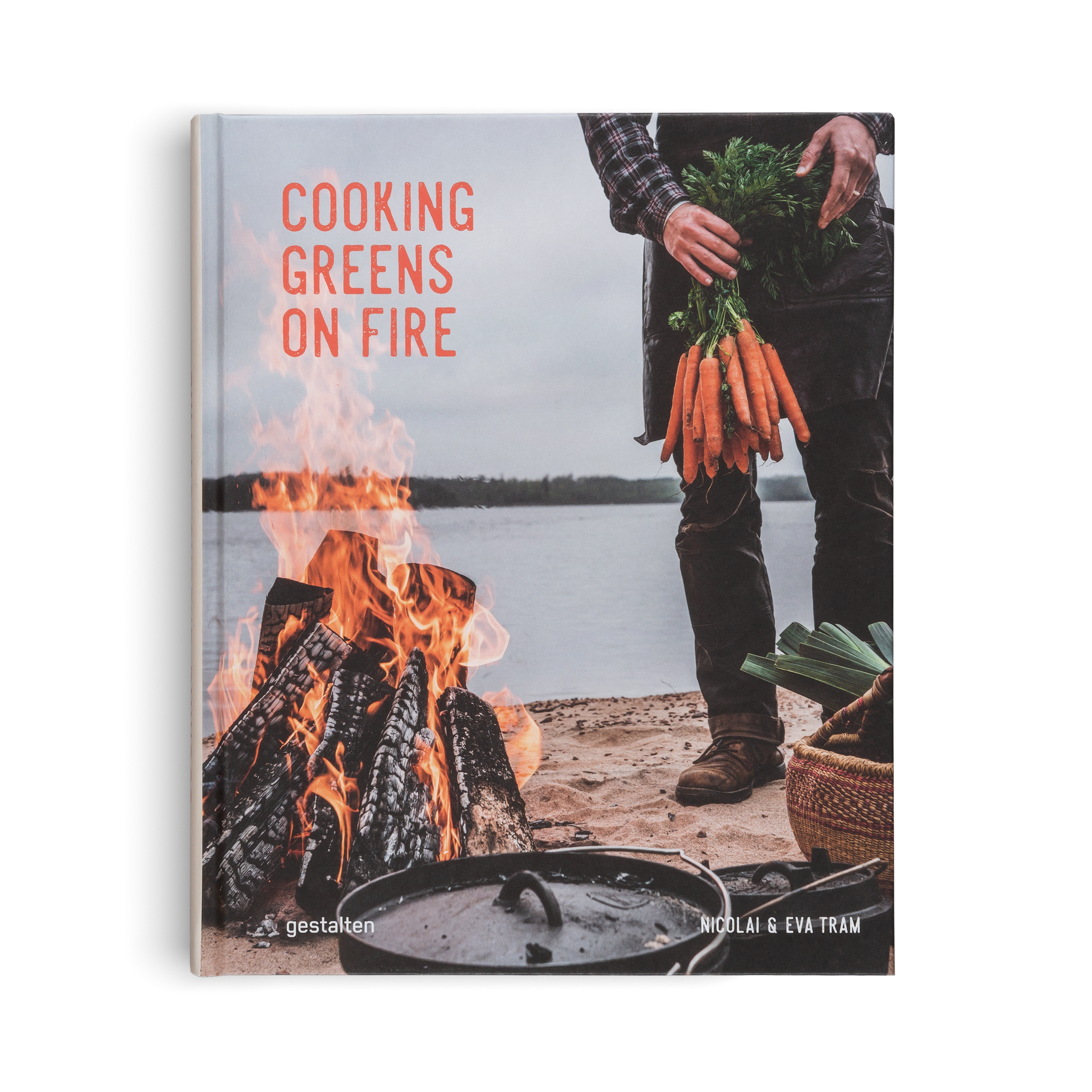 Book cover titled 'Cooking Greens on Fire' with a person holding carrots near a campfire.
