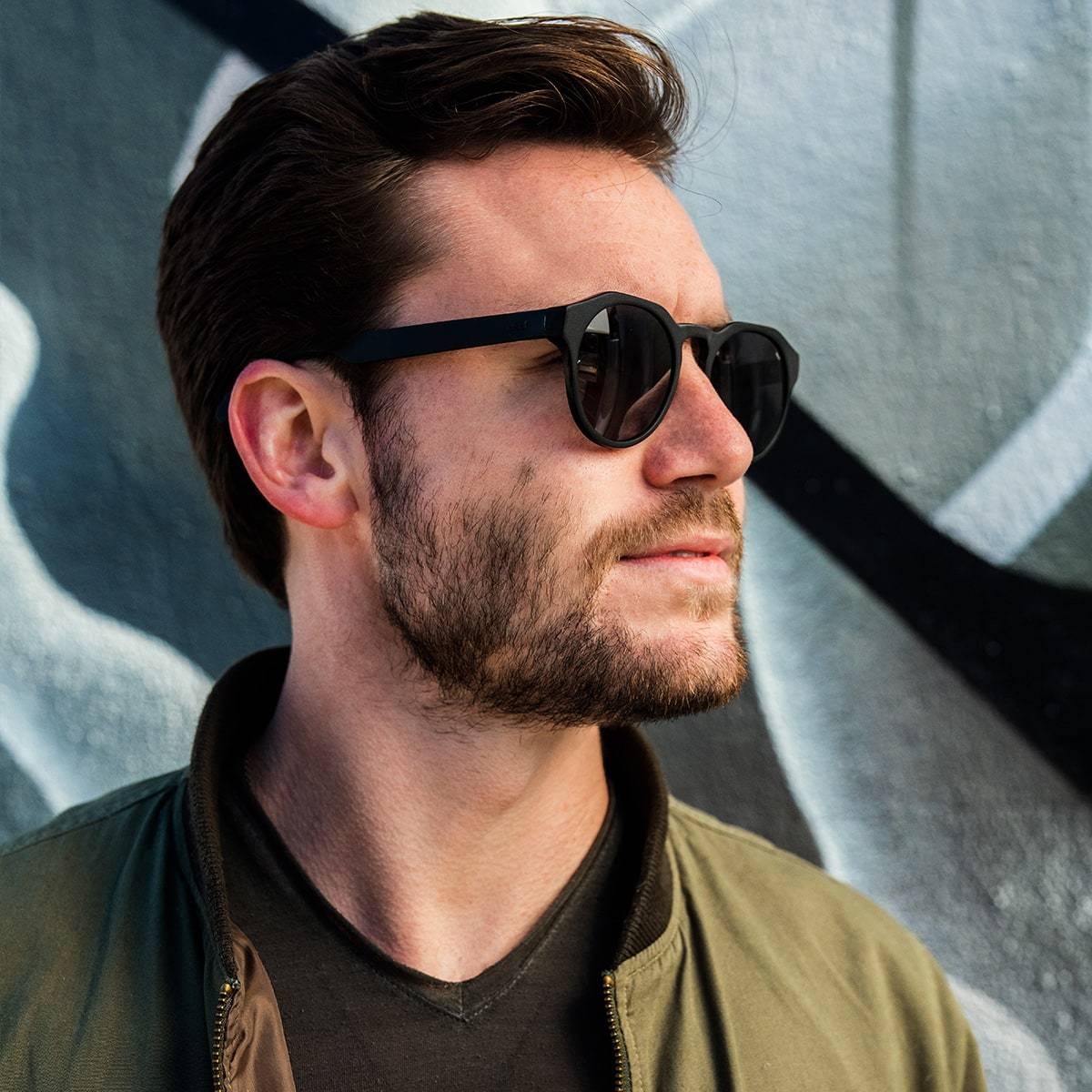 close up of late 20s man wearing distil cooper sunglasses with black frames and polarized lens
