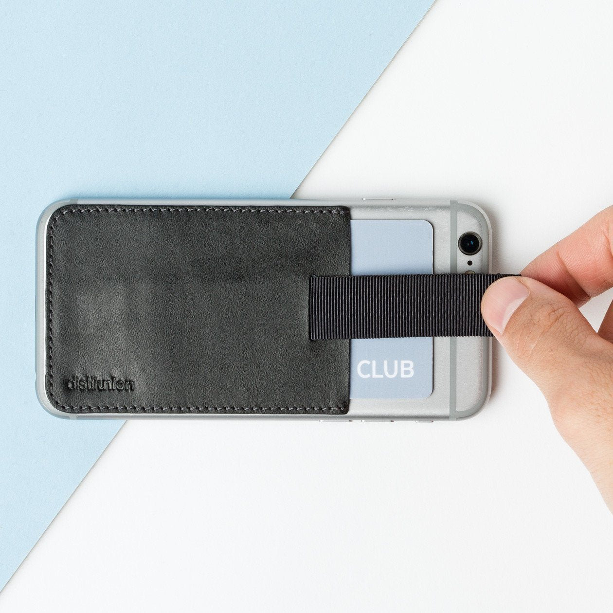 black leather wally junior stick-on attached to an iphone with hand using pull-tab to withdraw cards