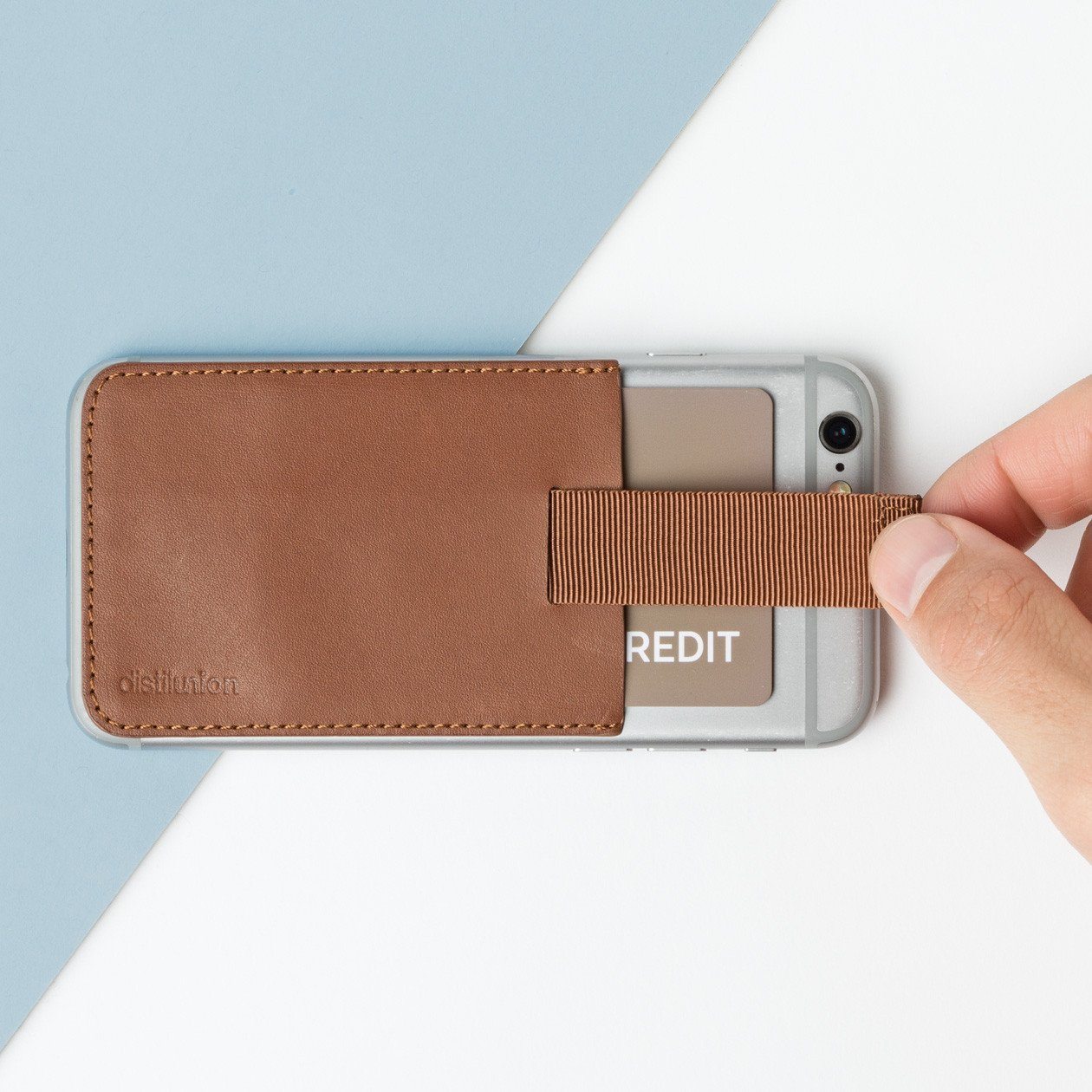 hickory leather wally junior stick-on attached to an iphone with hand using pull-tab to withdraw cards