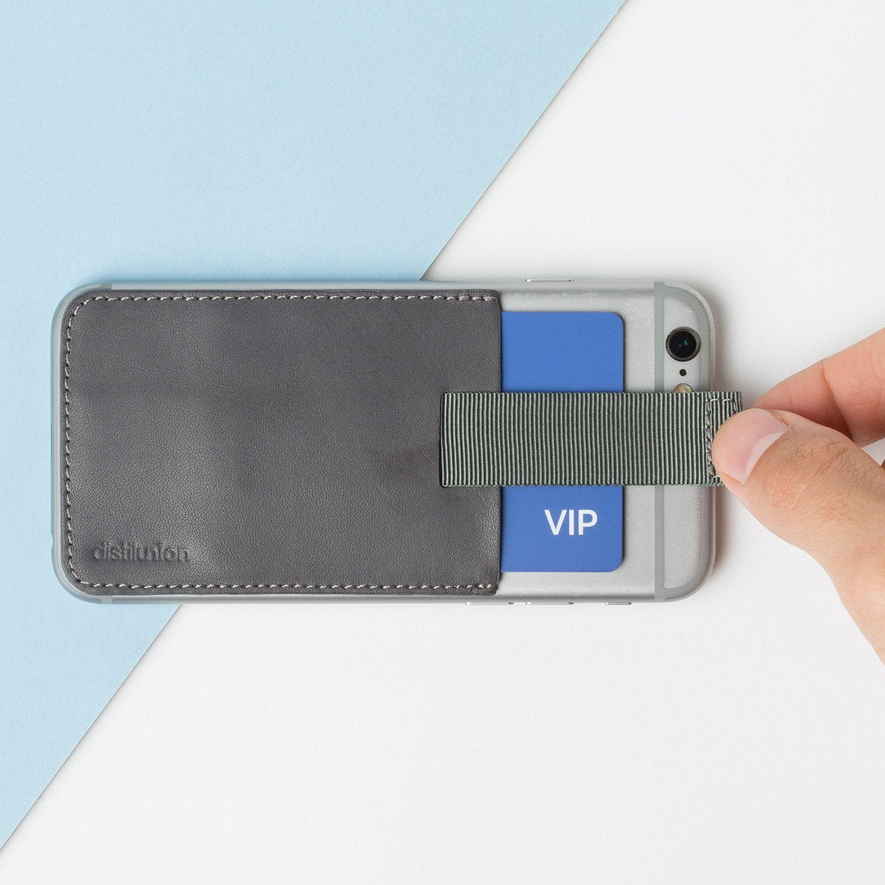 slate leather wally junior stick-on attached to an iphone with hand using pull-tab to withdraw cards