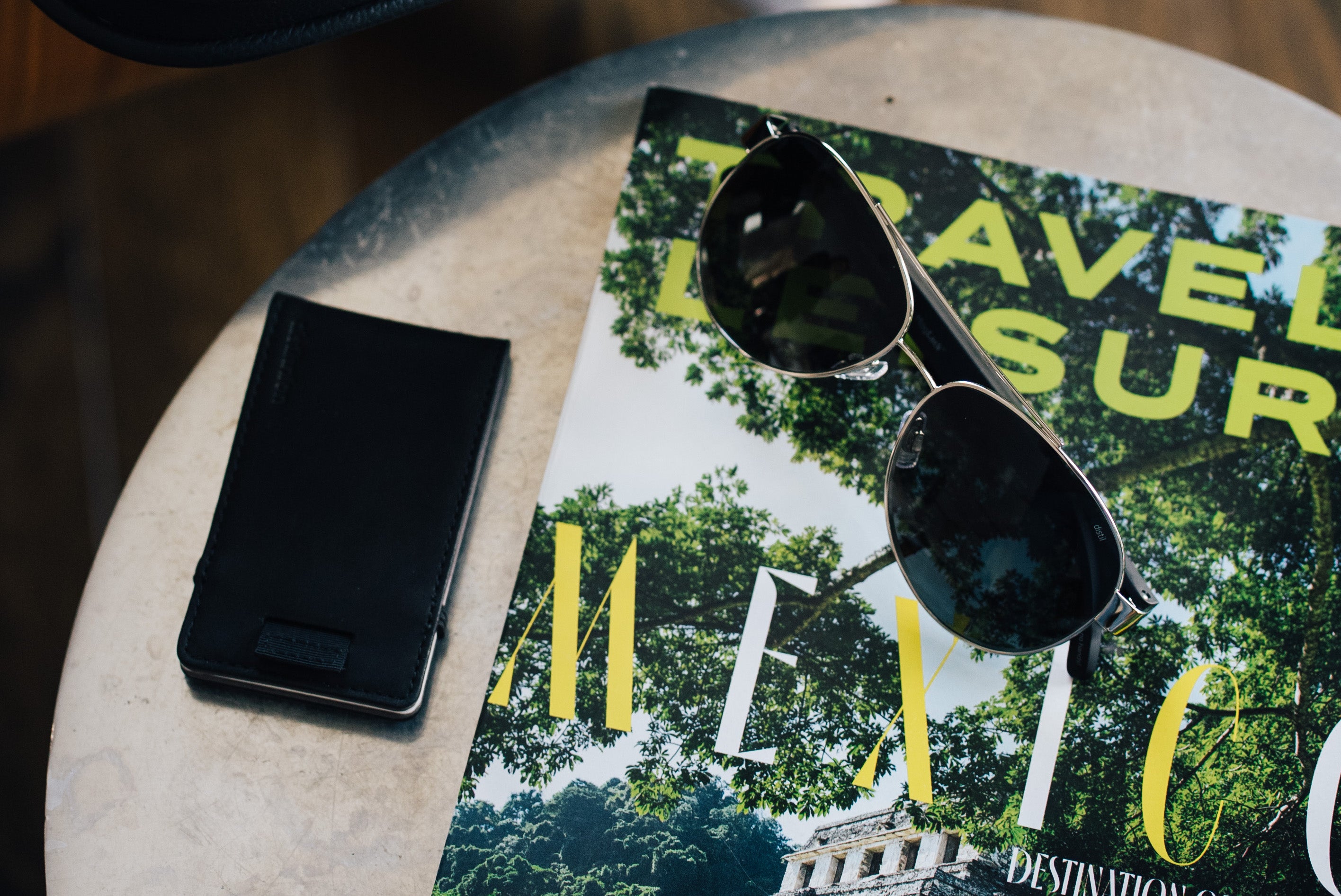 wally micro and maverick maglock sunglasses by distil union lays on a travel leisure magazine issue