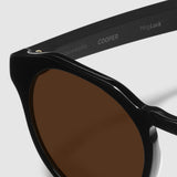 close up view of distil cooper sunglasses with black frames and amber polarized lens