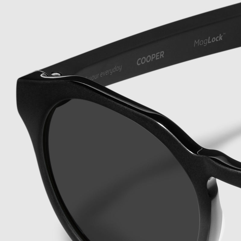 close up view of distil cooper sunglasses with matte black frames and polarized lens