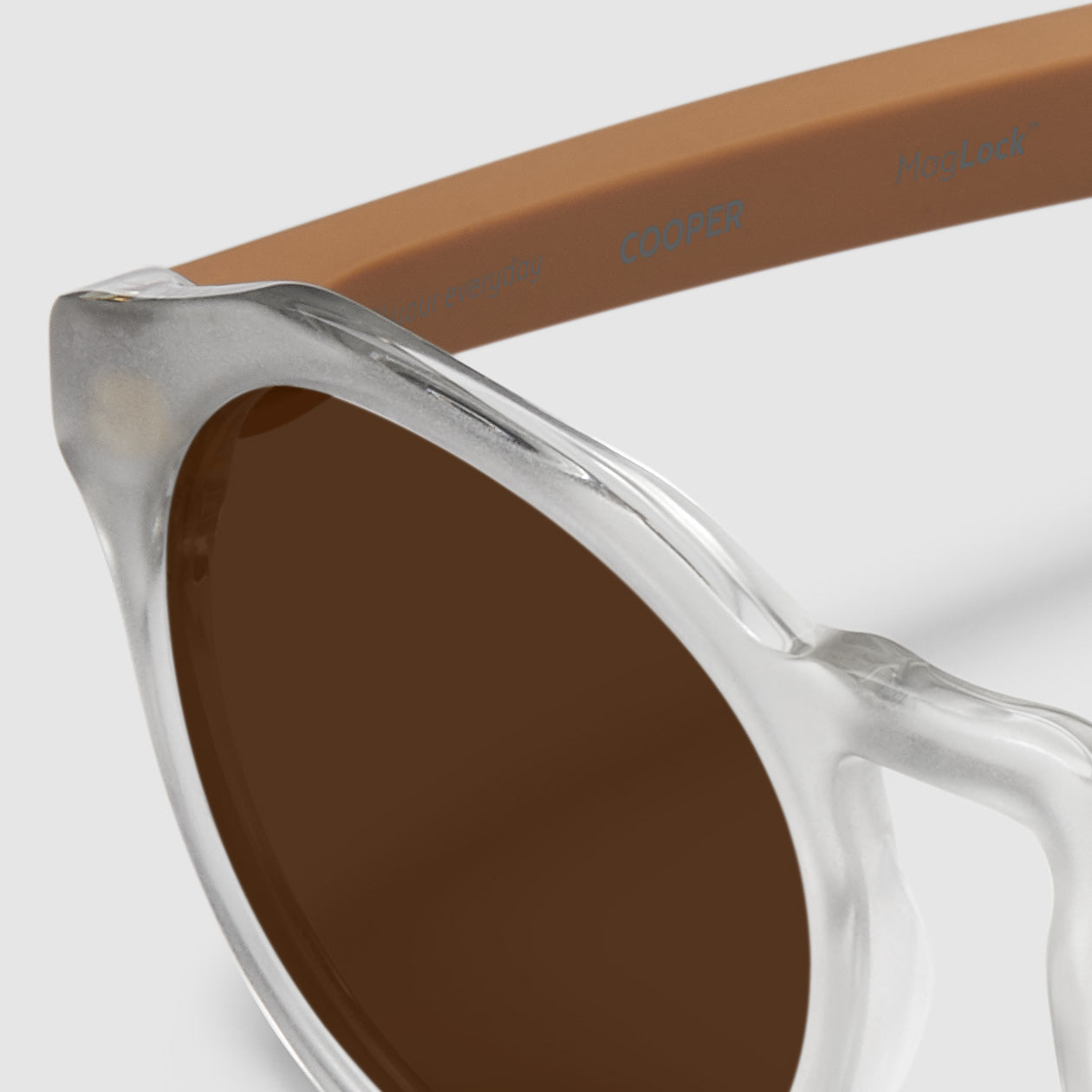 close up view of distil cooper sunglasses with matte crystal frames and amber polarized lens