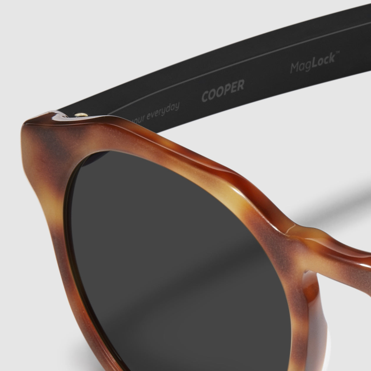close up view of distil cooper sunglasses with matte tortoise frames and polarized lens