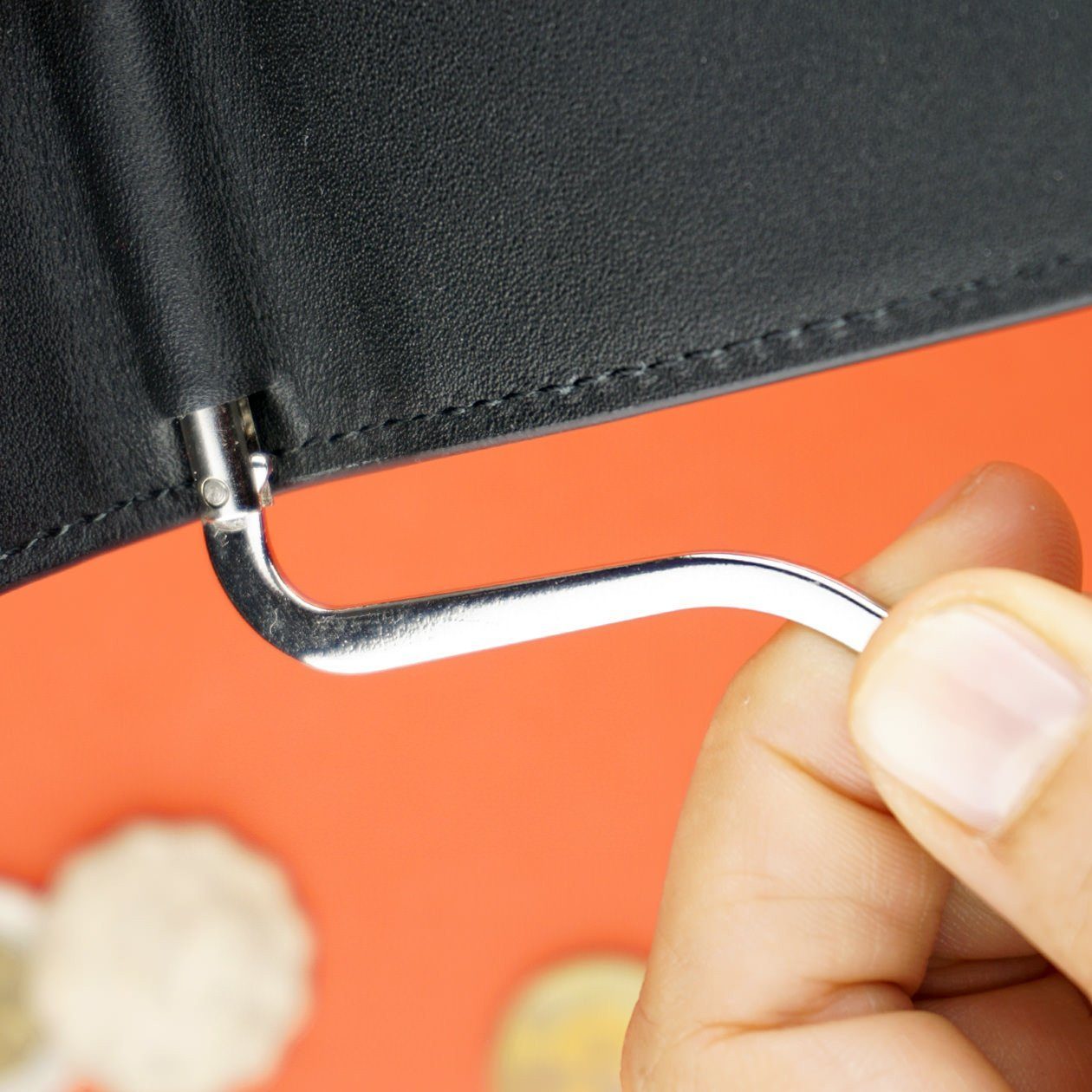 index and thumb holding an adjustable money clip attached to a black wallet