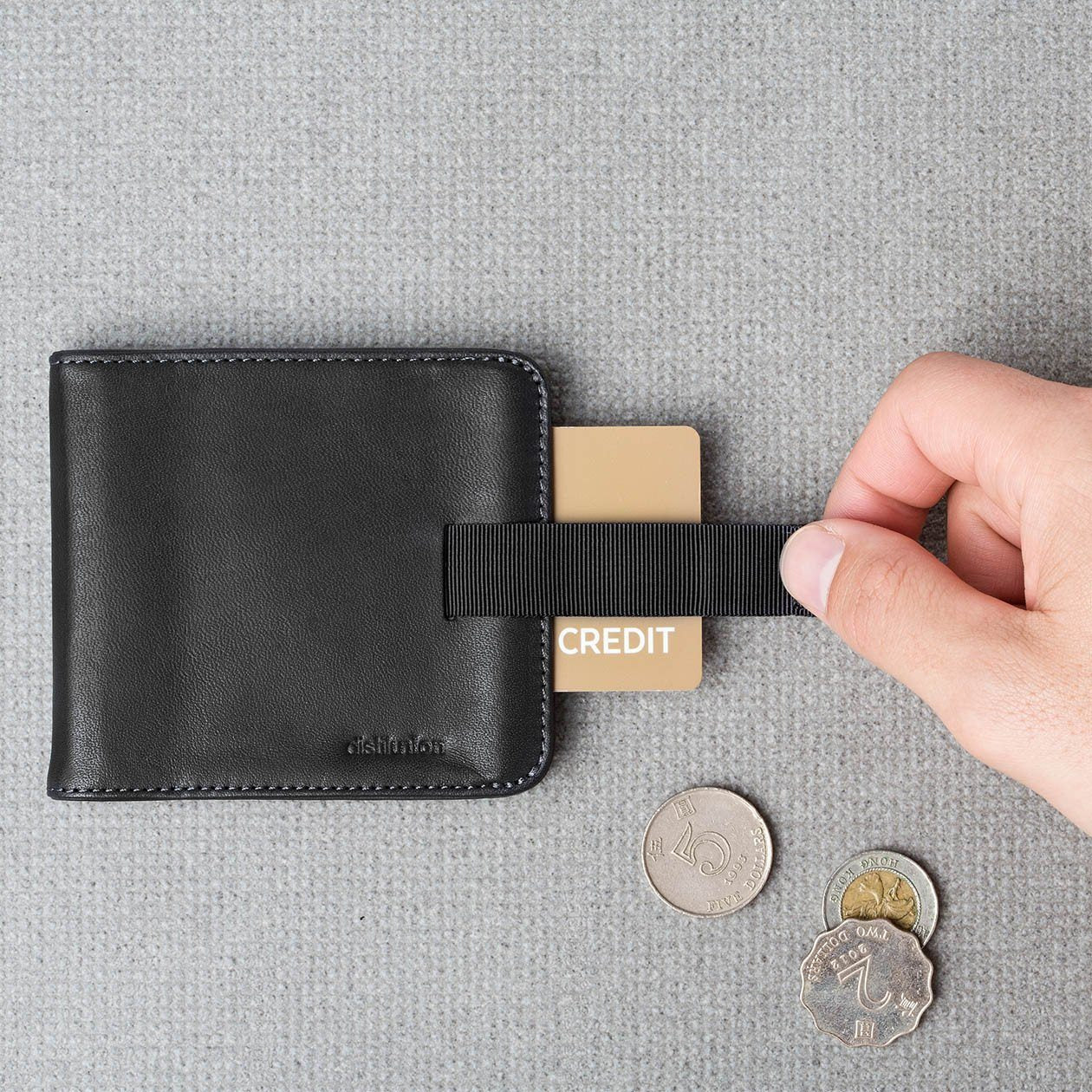 hand using pull-tab to extract brown card from black leather wally euro travel wallet